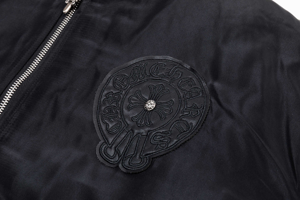 Black bomber jacket with large circular chest applique and textured stitching