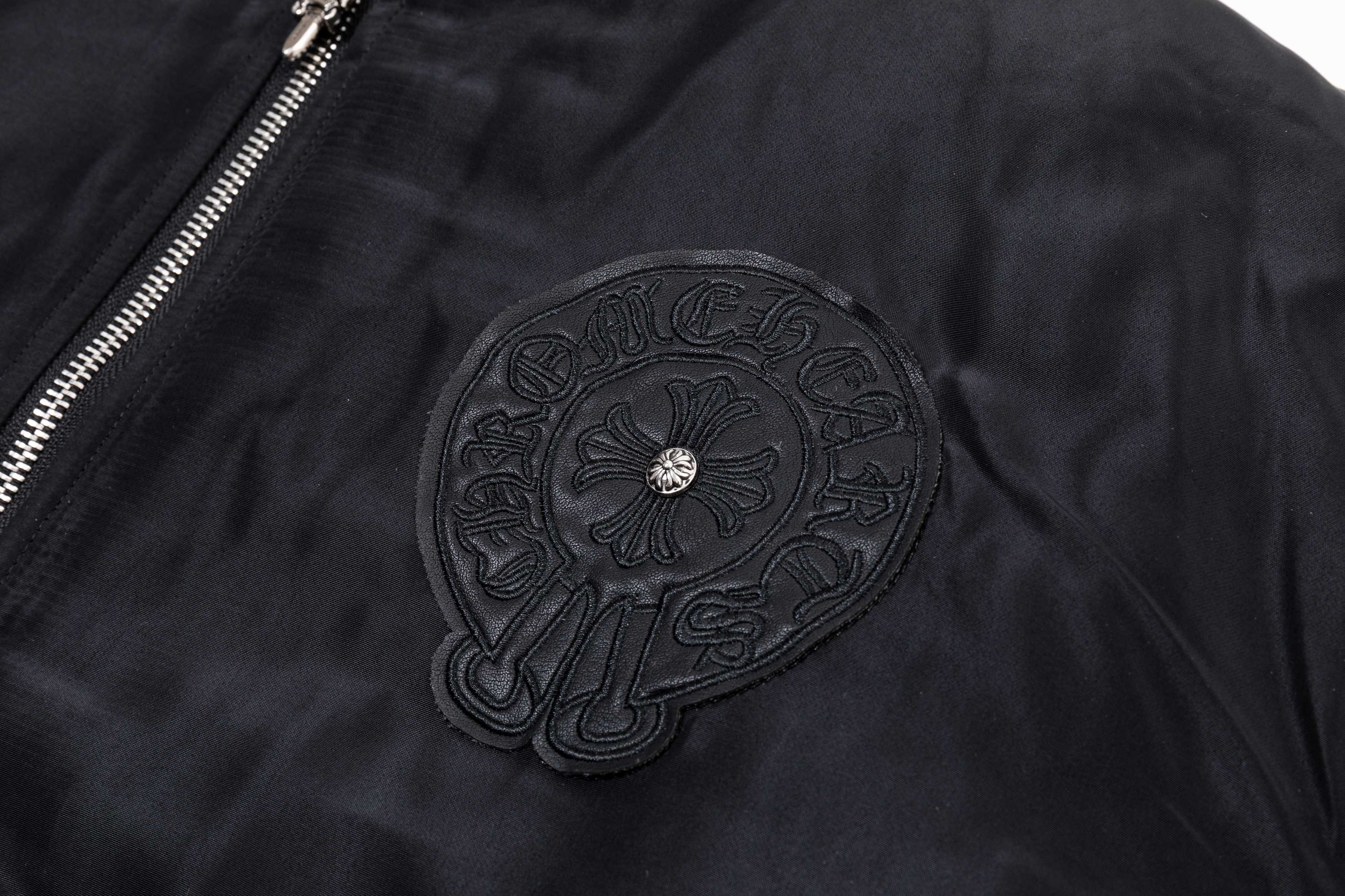 Black bomber jacket with large circular chest applique and textured stitching