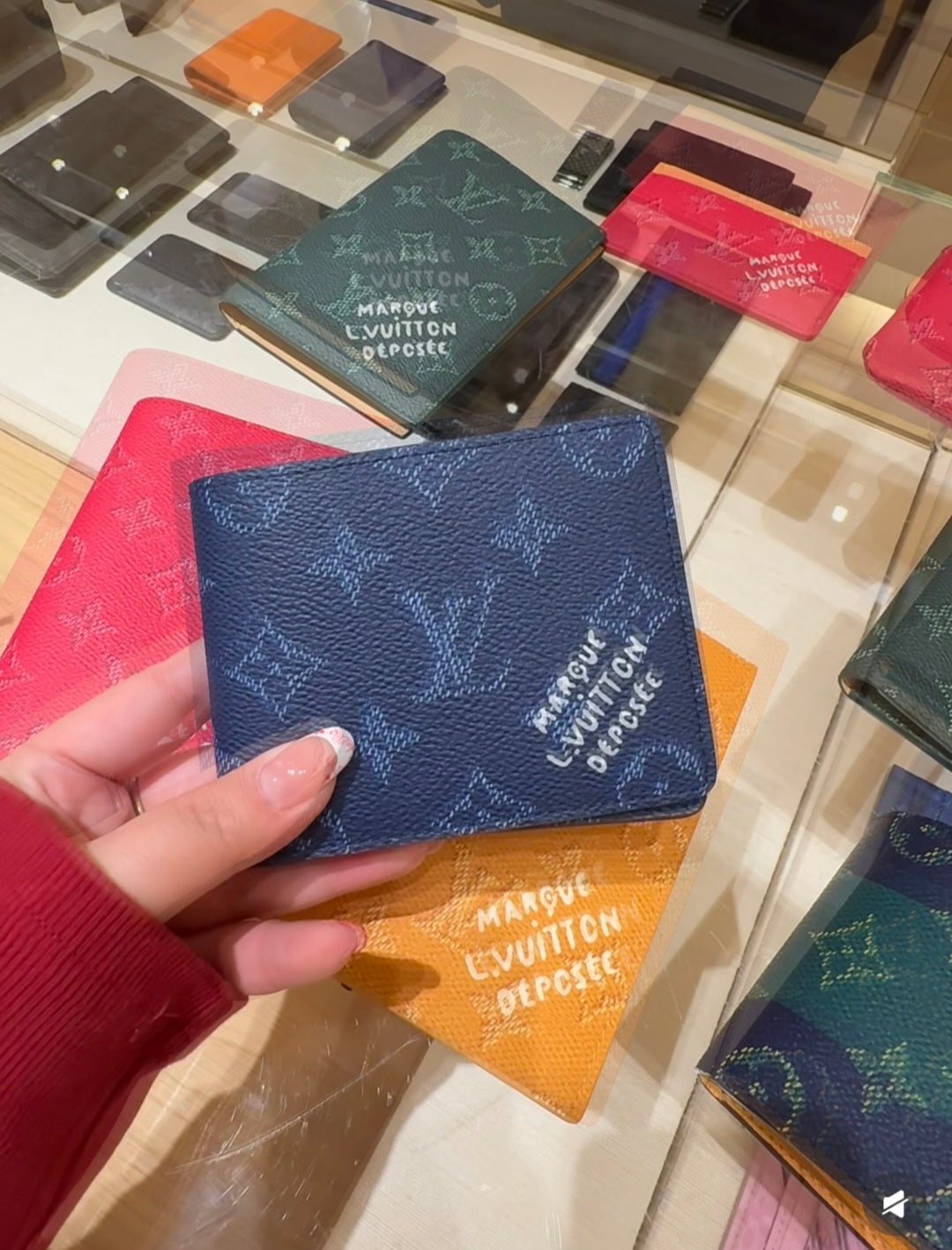 Louis Vuitton small pouch with blue monogram pattern, held in hand