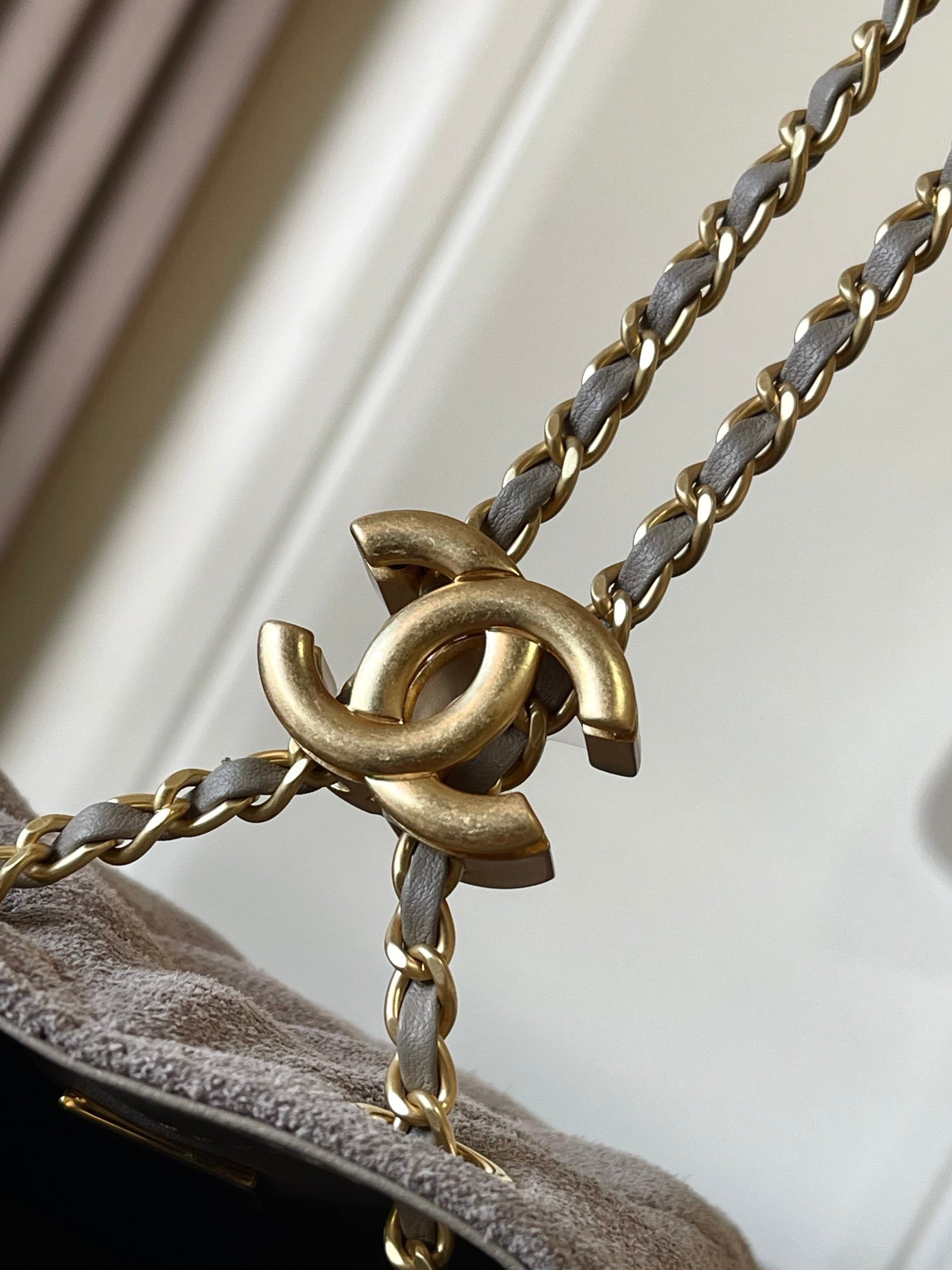 Chanel gold chain and clasp hardware on light gray flap edge