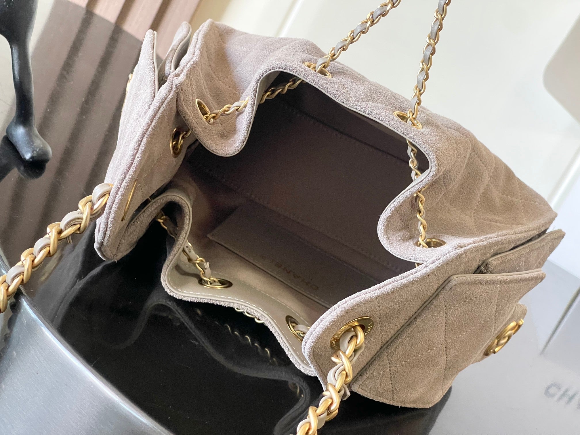 Chanel light gray flap bag open top with fabric lining and gold chain