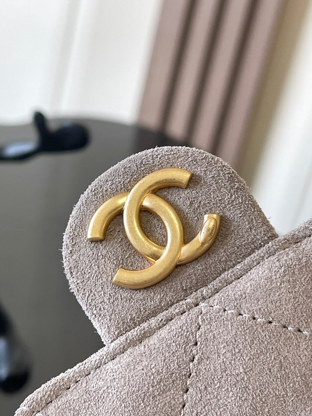 Chanel gold CC logo on light gray suede flap