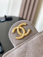 Chanel gold CC logo on light gray suede flap