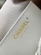 Chanel logo label on light gray fabric lining with stitched edge
