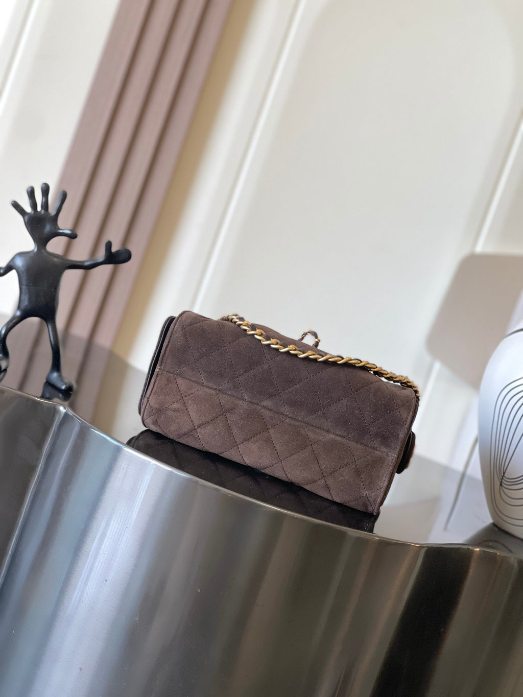 Dark brown quilted shoulder bag with gold chain strap and hardware detail