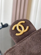 Gold CC logo on brown suede flap with stitched edge