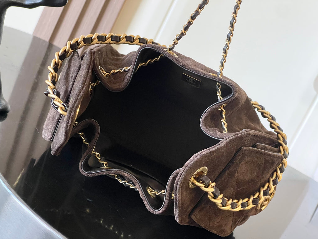 Dark brown suede shoulder bag open with gold chain strap and dark interior