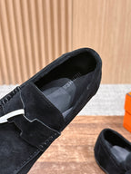 Hermes unisex black suede loafer close-up with logo emblem and smooth slip-on vamp