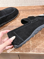 Hermes unisex black suede loafers close-up with strap and textured tread sole
