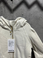 Cream hoodie with hood and gold zipper, hanging tag at chest