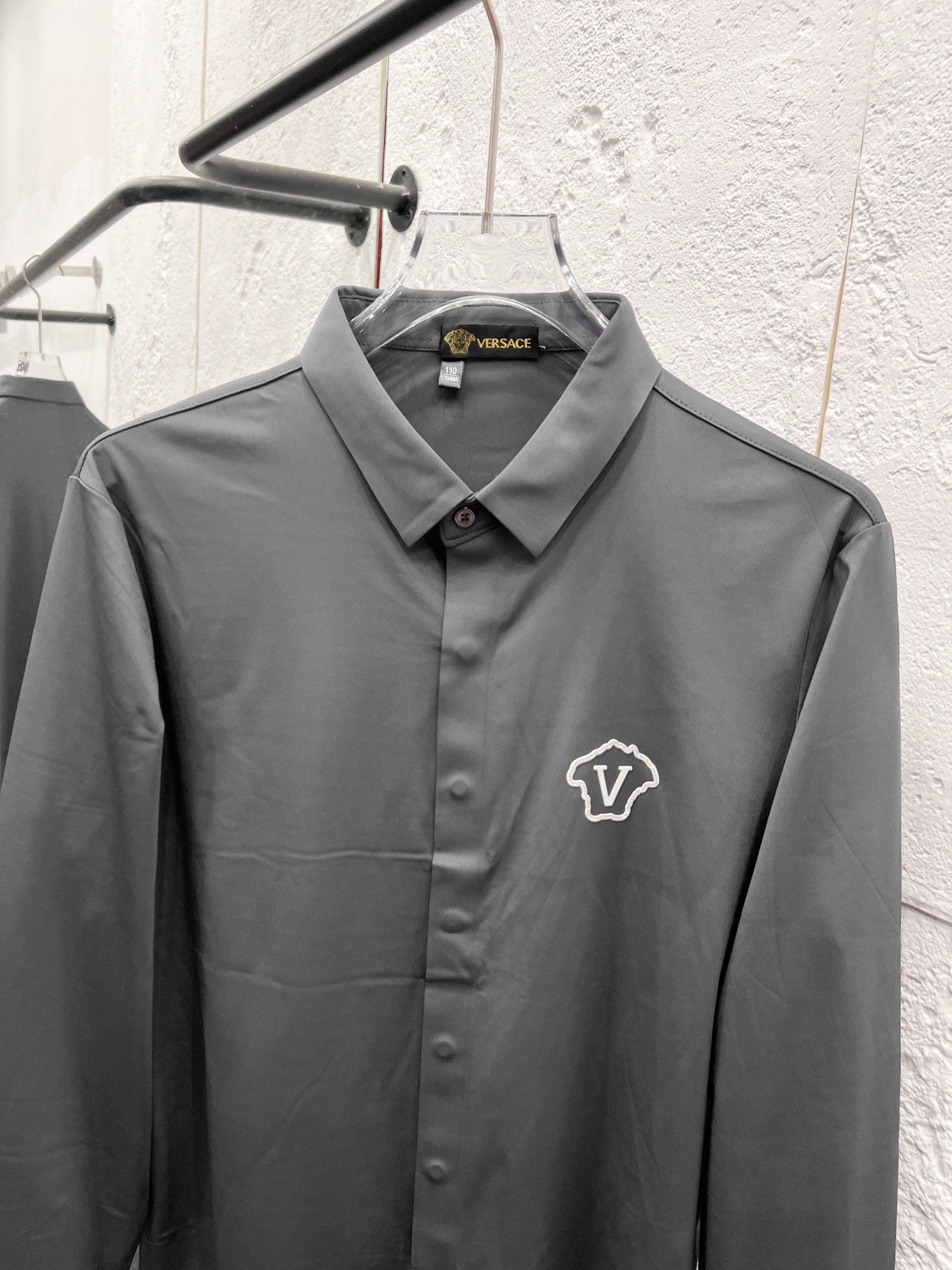 Versace button-up dress shirt, grey with crest logo and pointed collar.