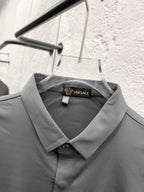 Versace dress shirt collar with inner label, grey button-up on hanger.