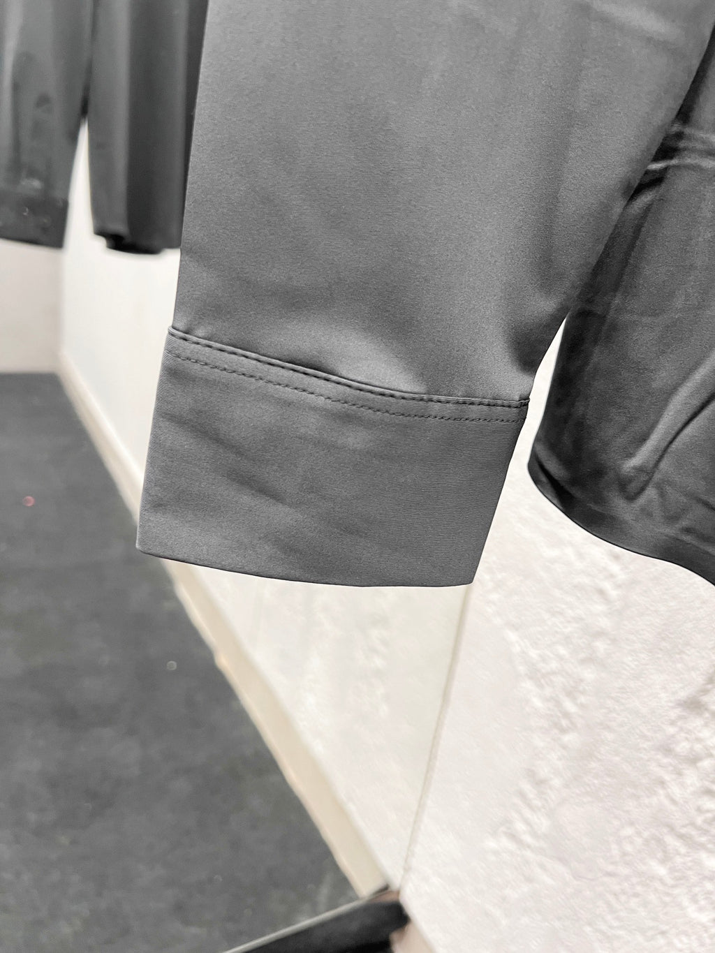 Versace shirt sleeve with stitched cuff edge, grey button-up.