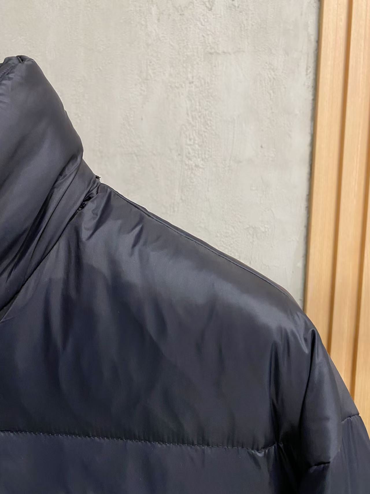 Prada puffer jacket shoulder and upper sleeve seam detail, dark padded fabric