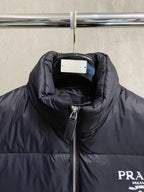 Prada puffer jacket close-up at collar and zipper with logo patch on chest