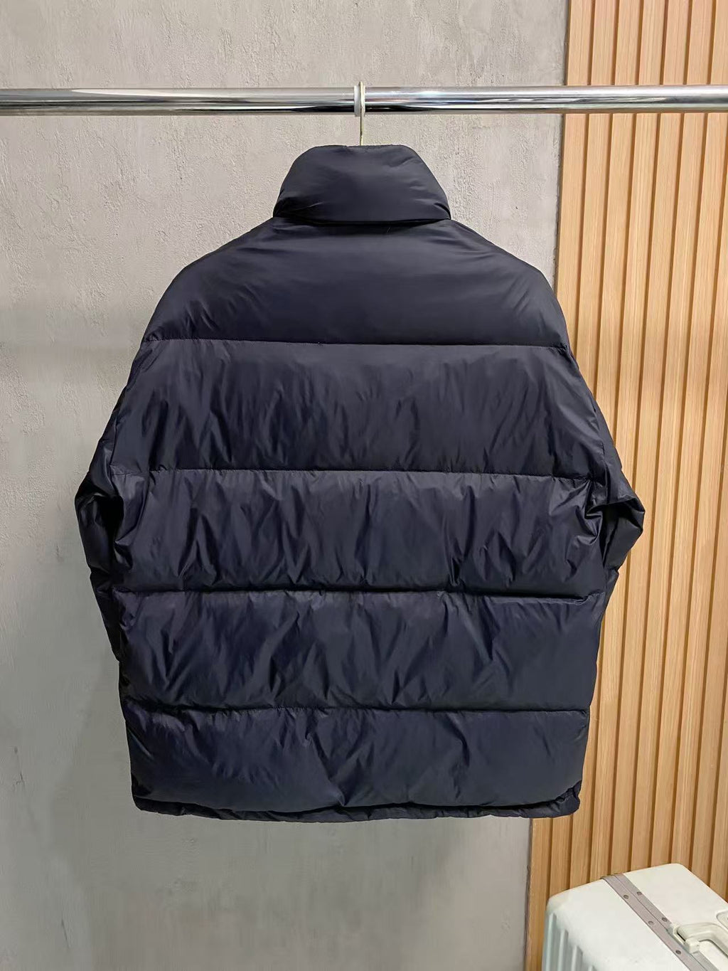 Prada puffer jacket back view with dark padded stripes and stand collar