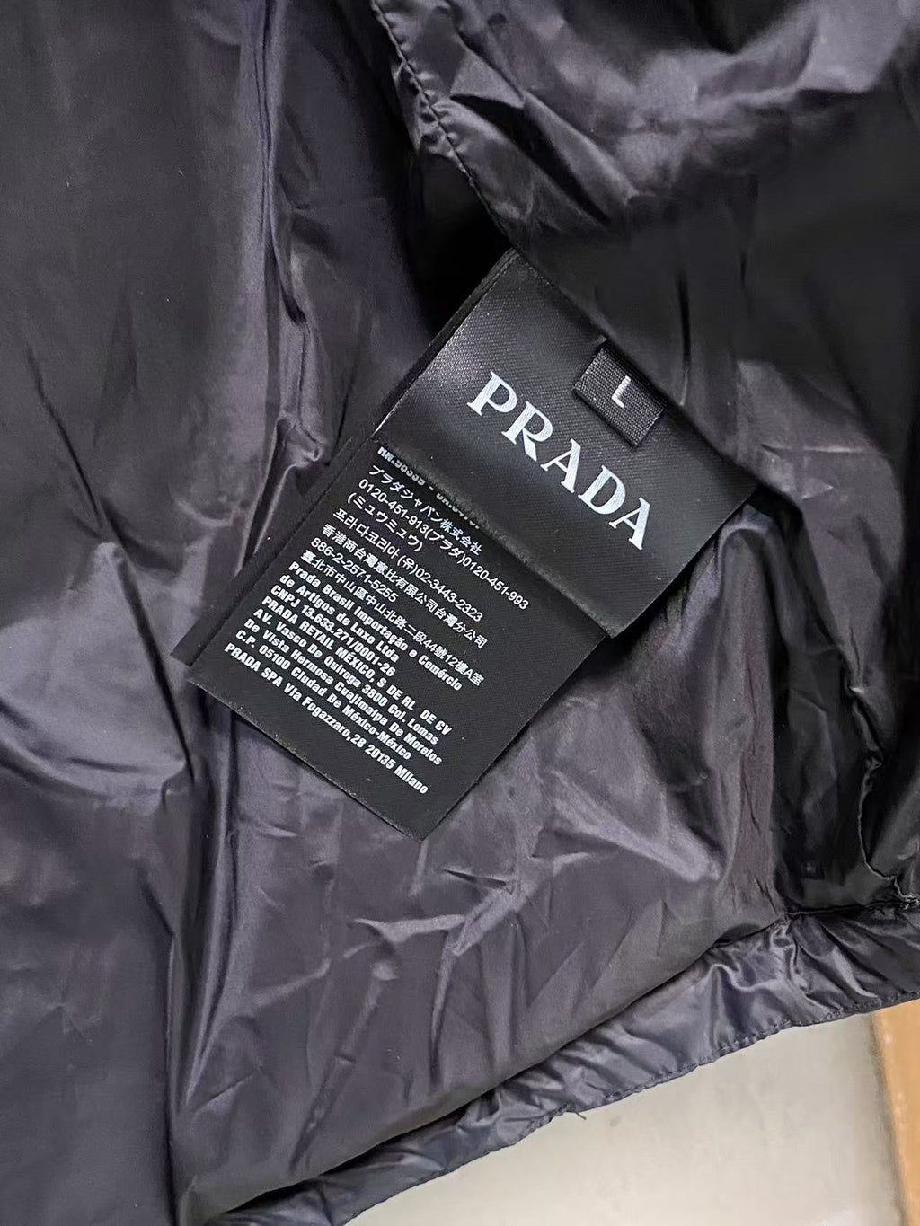 Prada puffer jacket interior with care label tag and PRADA branding