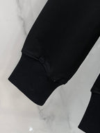Black sweatshirt sleeve cuff with ribbed knit hem and seam details