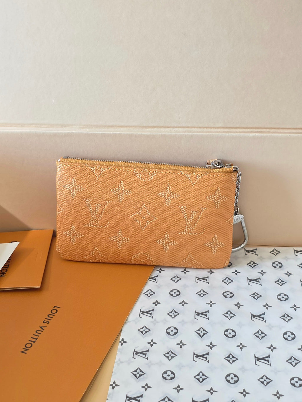 Small Louis Vuitton monogram bag with top zip and chain strap, tan/orange