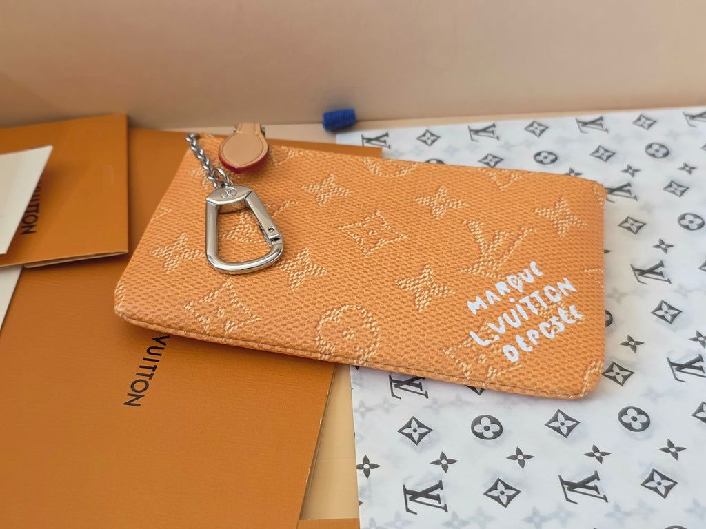 Louis Vuitton monogram zip pouch with decorative clasp, tan-brown textured canvas