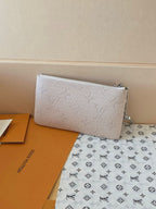 Light beige monogram zip pouch with silver chain strap, flat rectangular shape.