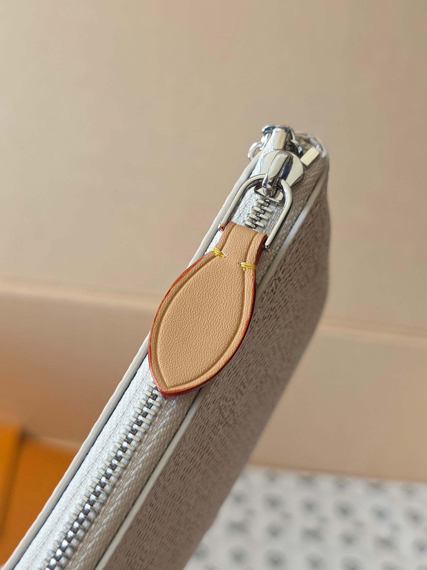 Small zip pouch side view with tan leather trim and silver chain hardware