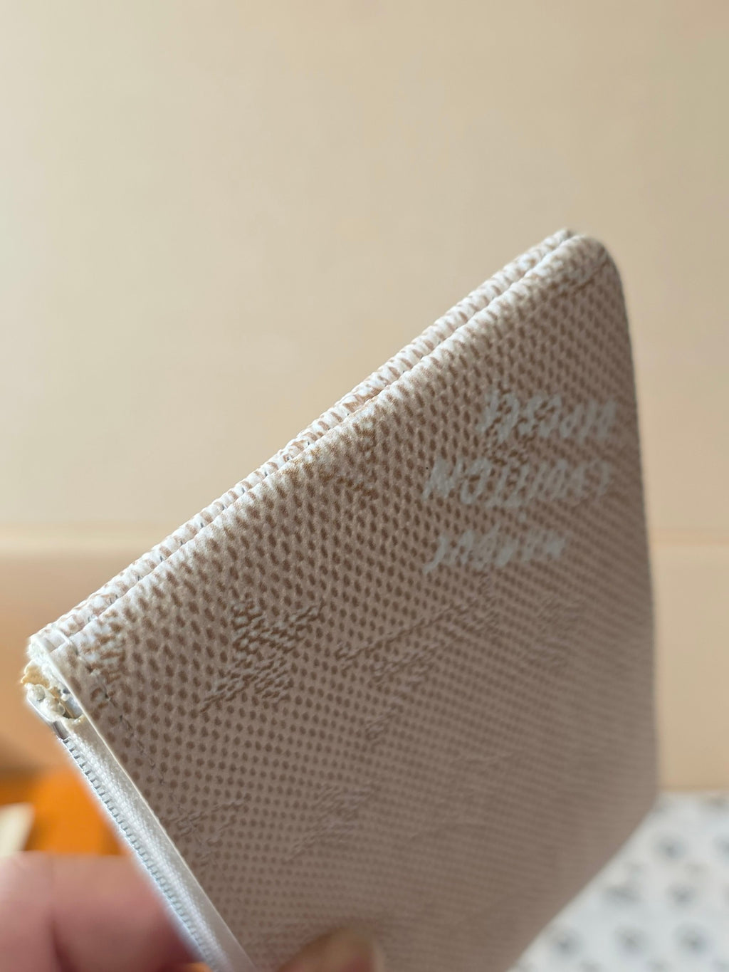 Small zip pouch back panel in light beige textured canvas with monogram print