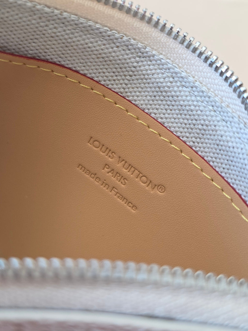 Tan leather interior patch with embossed LOUIS VUITTON and Made in France