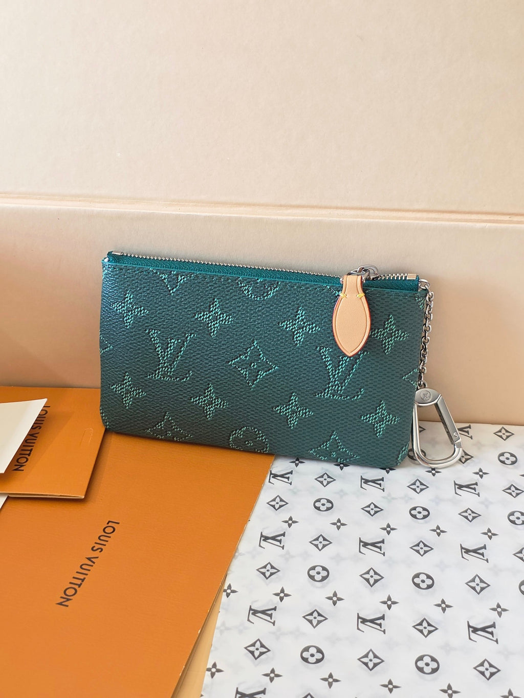 Teal monogram zip pouch with tan leather zipper pull and silver chain keyring