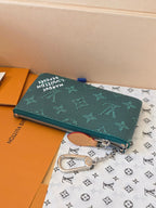 Louis Vuitton small bag with teal monogram print, top zipper, and chain strap
