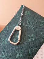 Louis Vuitton small bag close-up: teal monogram canvas with silver clasp and chain
