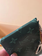 Louis Vuitton small bag corner close-up with teal monogram canvas and metal chain ring