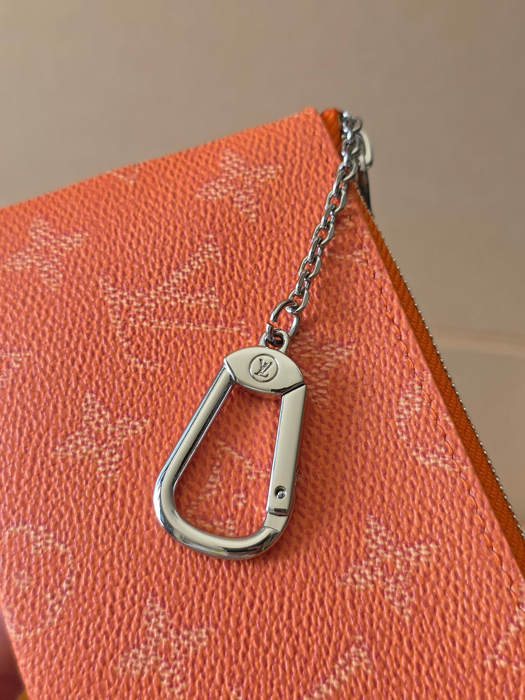 Orange textured pouch with silver D-ring keychain and metal chain links