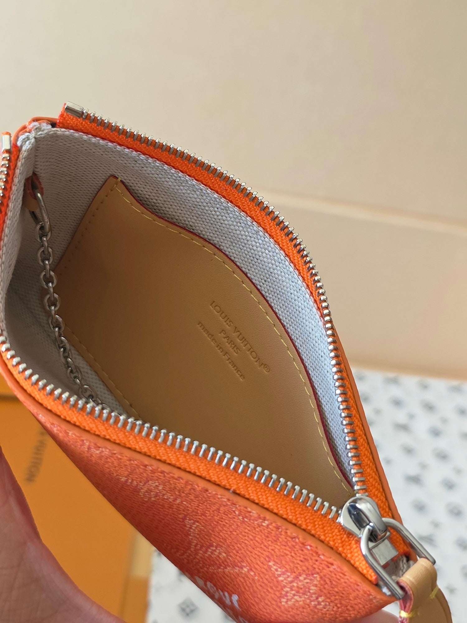 Orange monogram pouch with open zip and beige interior panel