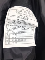 Black jacket care label with materials, wash instructions, and codes