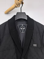 Louis Vuitton black quilted jacket front close-up with logo badge and buttons