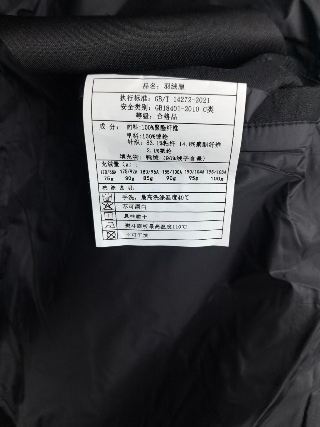Garment care label inside black quilted jacket