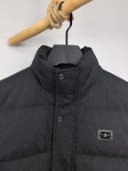 Black puffer jacket close-up: stand collar, front buttons, chest label patch