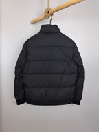 Black long-sleeve puffer jacket, back view, full zipper and quilted panels