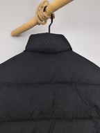 Black puffer jacket back view with high collar and quilted geometric pattern