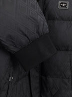Black puffer jacket fabric detail with ribbed cuff and logo label