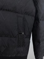 Black puffer jacket side view with center front zipper and logo emblem