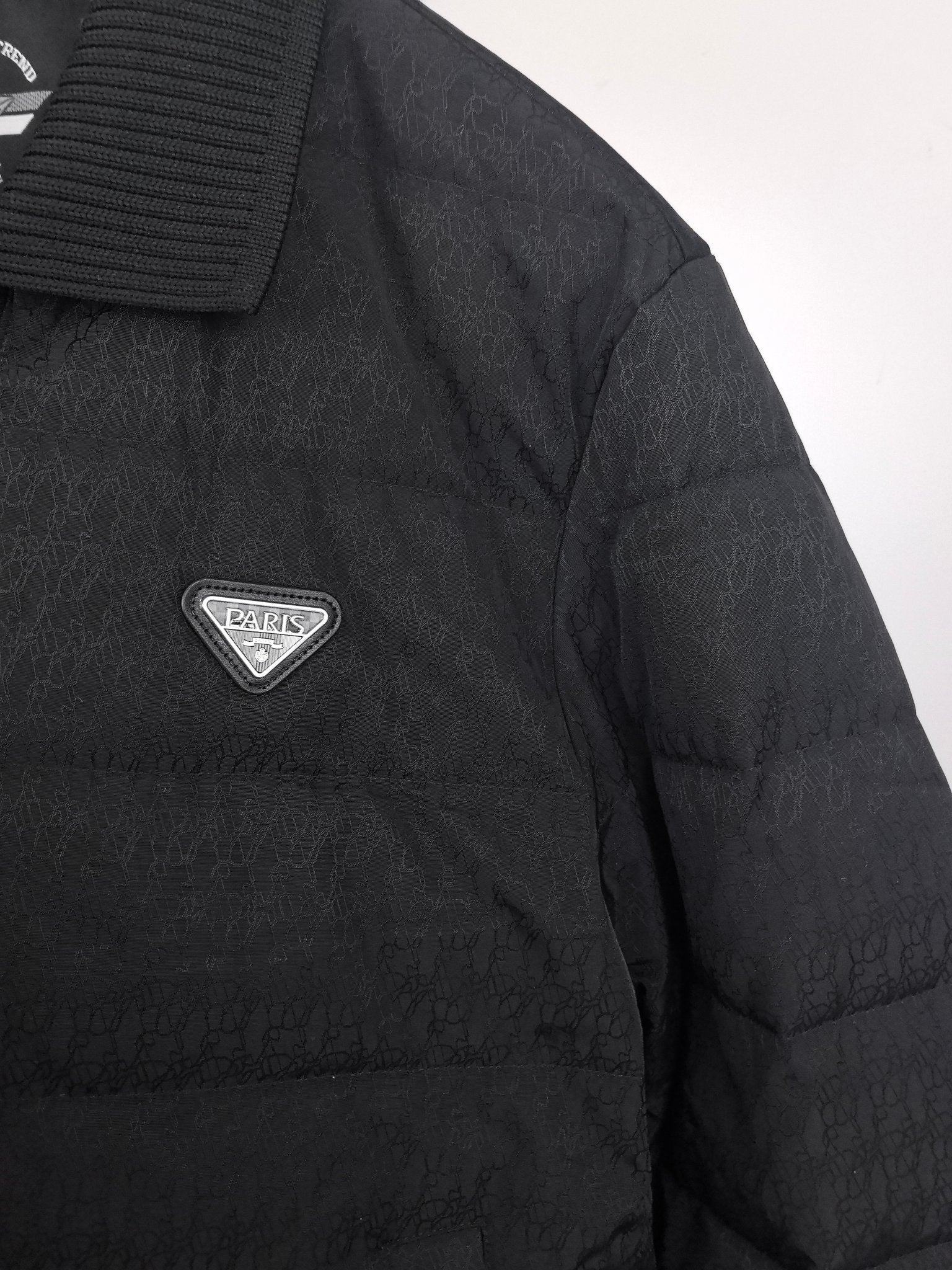 Prada puffer jacket side panel with triangular PARIS logo patch