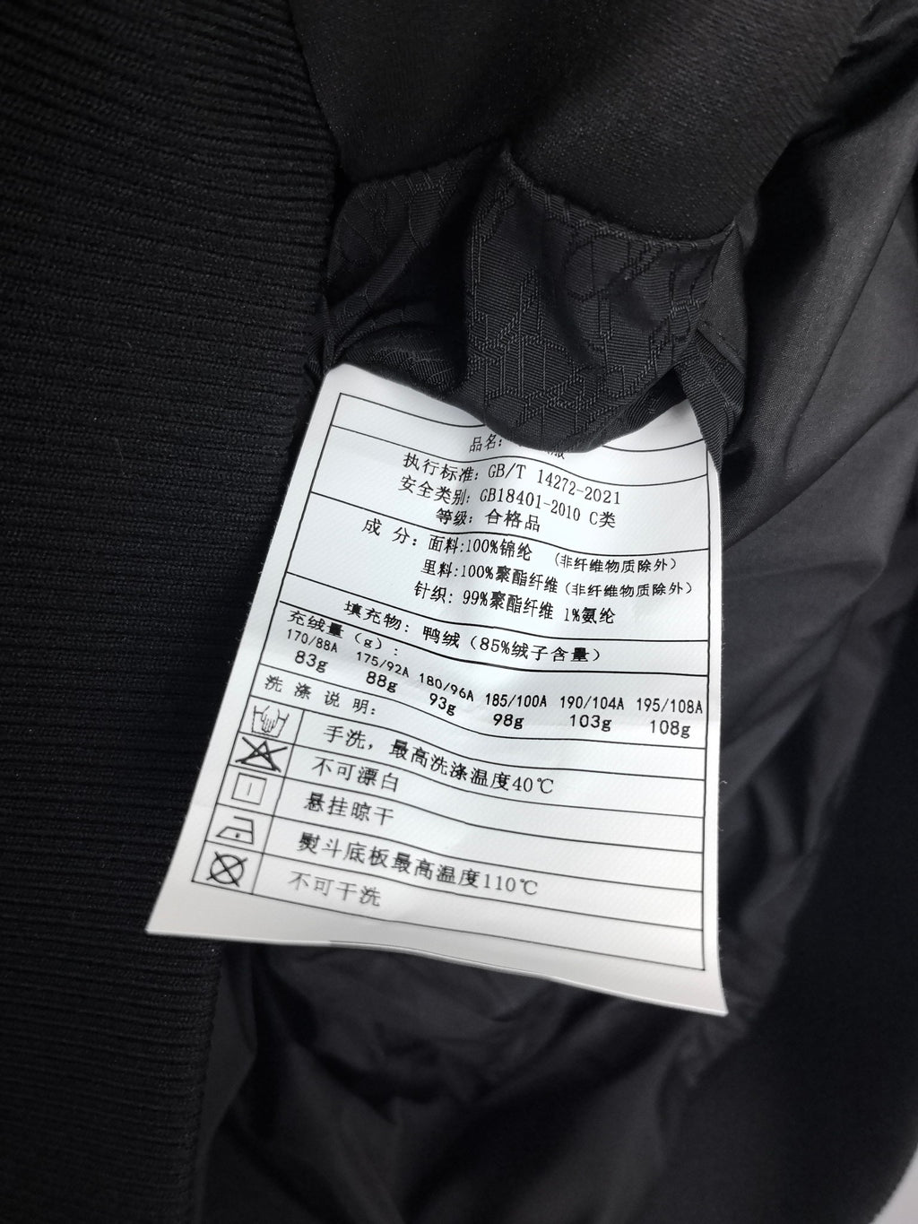 Prada puffer jacket interior care label tag near collar seam