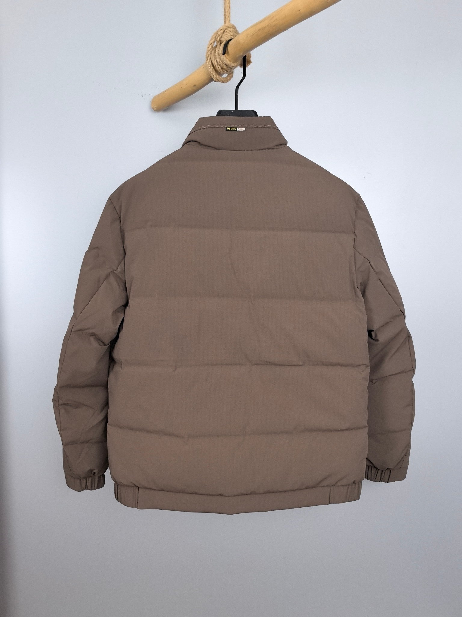 Prada long puffer jacket taupe, back view with high collar and central zip