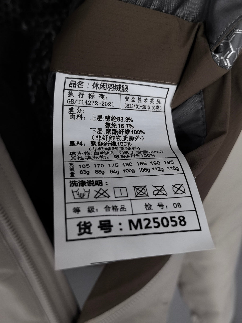 White care label on beige padded jacket with size and fabric information
