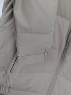 Light beige padded jacket side with zip pocket and stitched seam