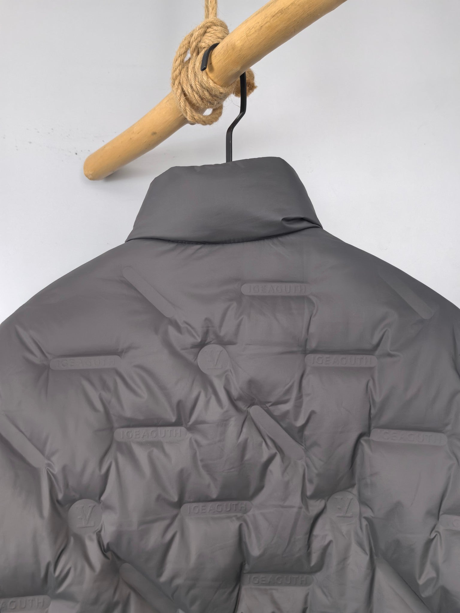 Louis Vuitton puffer jacket, dark gray, back view close-up with logo plaque