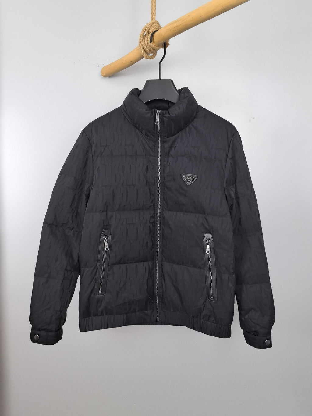 Prada quilted puffer jacket in dark color with full front zip, stand collar, logo patch