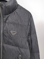 Prada dark puffer jacket close-up with logo patch and side seam zipper